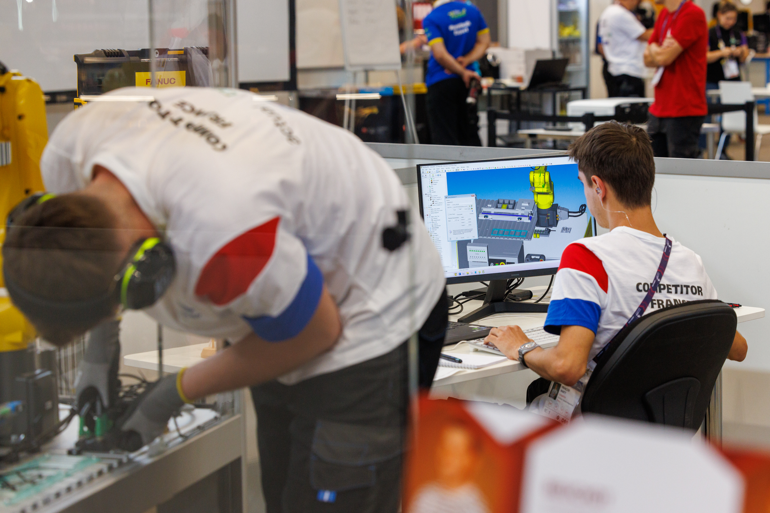 Pendant que François programme sur ordinateur, Thomas effectue les opérations sur le robot. La coordination entre les deux membres du binôme est essentielle pour réussir dans la compétition. Photo : Xavier Ducordeaux